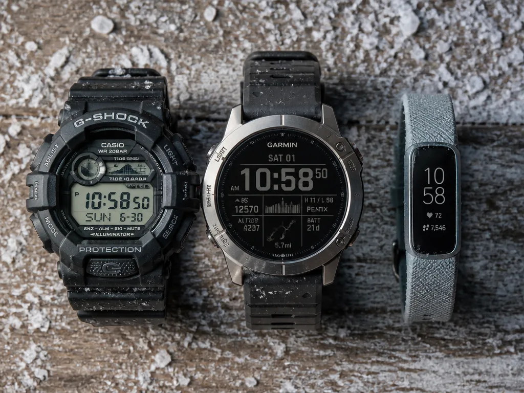 A macro photograph of three sports watches laid in a precise row on a…